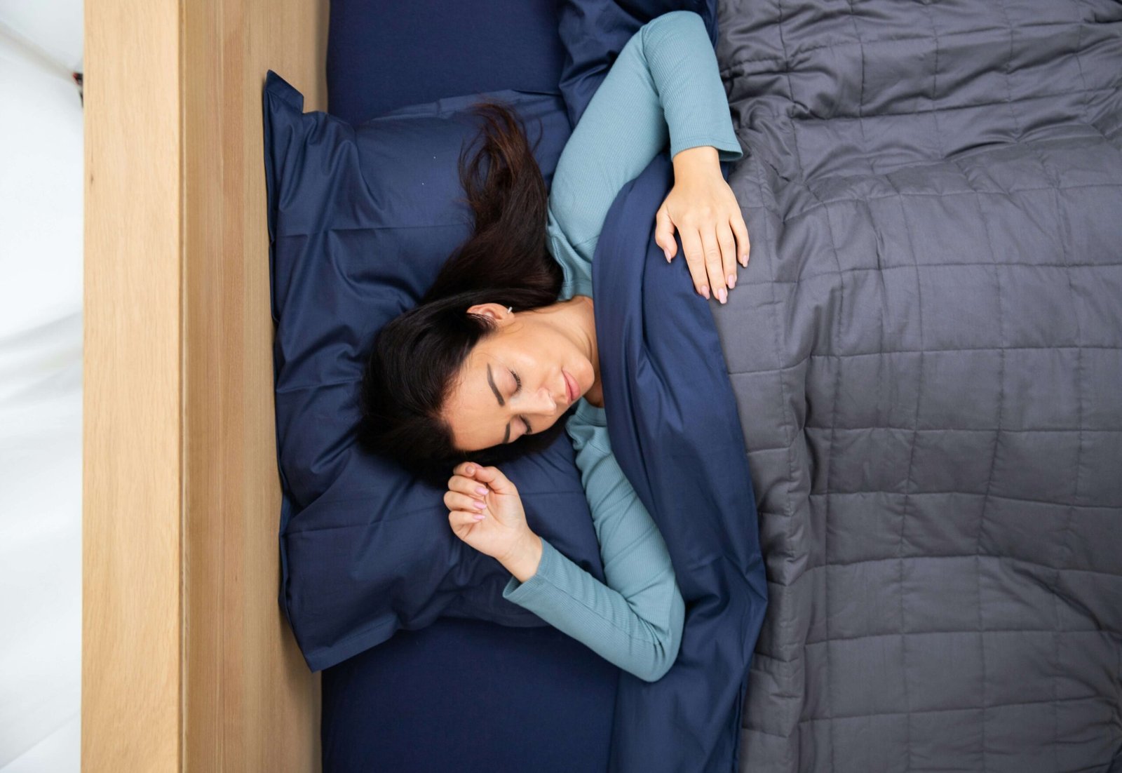 Person using weighted blanket to improve deep sleep naturally